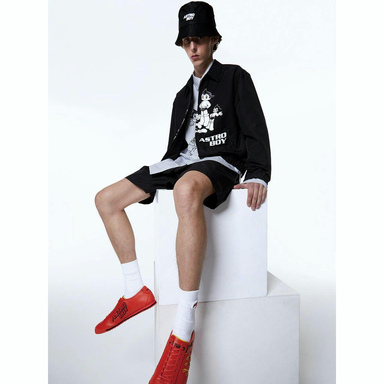 person sitting shoe sneaker boy male teen coat shorts hat